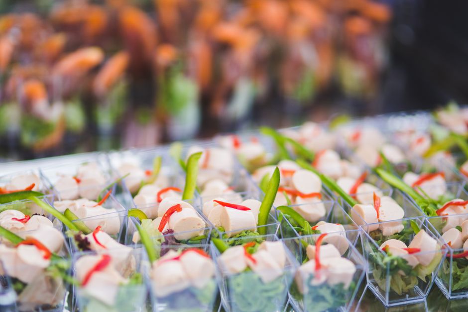 Verrines apéritives garnies de légumes frais et de morceaux de poulet, présentées sur un plateau.