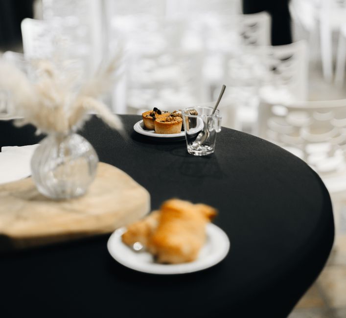 Table de réception avec des tartinades, pains sans pétrissage et décorations élégantes en arrière-plan.